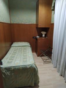 1 dormitorio con cama, mesa y cortinas en Atlantide Hotel, en Venecia