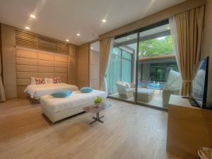 Un dormitorio con una cama, un sofá y un televisor. en Treescape Resort Chiangmai, en Chiang Mai