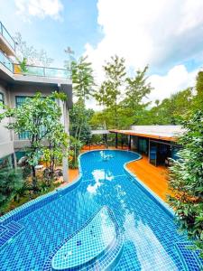 una gran piscina azul junto a un edificio en Treescape Resort Chiangmai, en Chiang Mai
