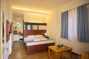 a hotel room with a bed and a table at Siman Panglao in Panglao Island