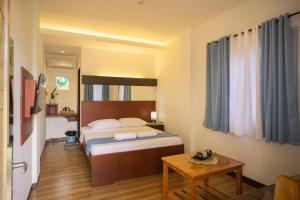 a hotel room with a bed and a table at Siman Panglao in Panglao