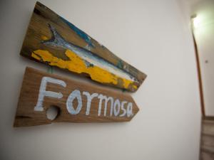 Formosa Guest House في تافيرا: علامة تقول fomos معلقة على الجدار