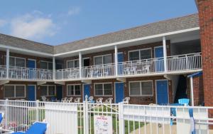 an exterior view of a building with a white fence at Colton Court Motor Inn in Cape May