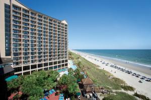 Blick auf ein Hotel und einen Strand mit einem Gebäude in der Unterkunft Beach Cove Resort in Myrtle Beach