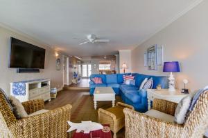 sala de estar con sofá azul y sillas en Work Friendly Oceanfront SURF25 Condo, en Solana Beach