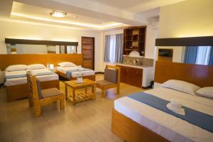 パングラオにあるSiman Panglaoのベッド2台とキッチンが備わるホテルルームです。