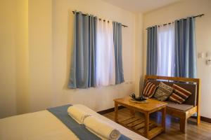 1 dormitorio con 1 cama, 1 mesa y 1 silla en Siman Panglao, en Panglao