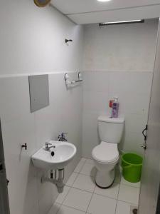 a white bathroom with a toilet and a sink at TAMU HOMESTAY in Kuala Terengganu