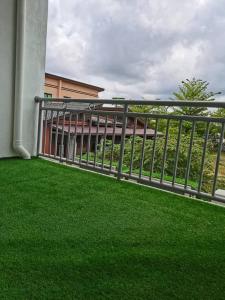 a balcony with green grass in front of a building at TAMU HOMESTAY in Kuala Terengganu