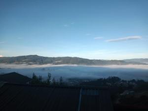 a view of a foggy valley with mountains at Cabaña del Colibri, la Guacamaya y la Mariposa in Sopo