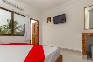a white bedroom with a bed and a television at Blossoming Romduol Boutique in Siem Reap