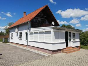 una casa bianca con tetto rosso di schönes Ferienhaus mit grossen Pool 250 m vom Balaton a Balatonmáriafürdő