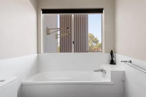 邦加里Keith's on Pumicestone, 1 of the 3 most popular units on Bribie的带水槽和镜子的白色浴室