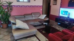 uma sala de espera com um sofá e uma televisão em Tommy Apartman em Hajdúszoboszló