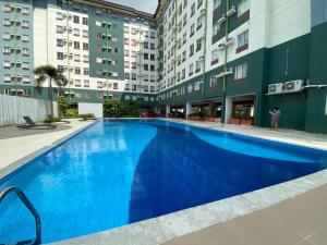 Budget Studio Flat near Airport-Amaia Steps Mandaue Condominium في ماكتان: مسبح ازرق كبير وسط مبنى