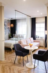 un soggiorno con divano, tavolo e letto di Apartamenty Zamkowe Centrum a Kwidzyn