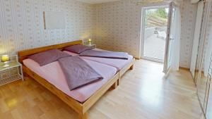 Un dormitorio con una cama con almohadas moradas. en Lorth´s Inn Ferienwohnung, en Kleinblittersdorf
