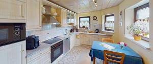 cocina grande con mesa azul y sillas en Lorth´s Inn Ferienwohnung, en Kleinblittersdorf