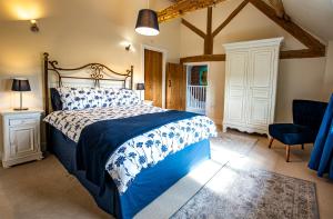 a bedroom with a large bed and a chair at Fabulous Listed Barn with the Best Valley View in Stanford on Teme
