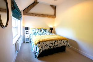 a bedroom with a bed in a room with a window at Fabulous Listed Barn with the Best Valley View in Stanford on Teme