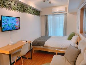 1 dormitorio con 1 cama y escritorio con escritorio en Dash Living Shinjuku, en Tokio