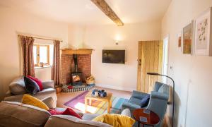 a living room with a couch and a fireplace at Fabulous Listed Barn with the Best Valley View in Stanford on Teme