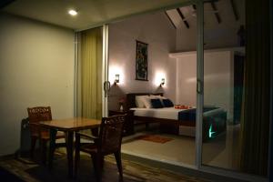 a bedroom with a bed and a table and chairs at Piyum villa in Weligama
