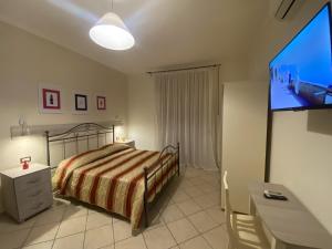 a bedroom with a bed and a flat screen tv at The Reef Apartment in Sorrento +13 photos