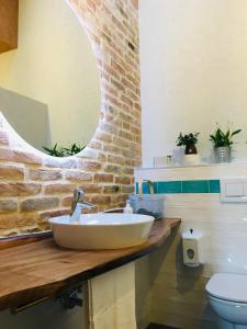 baño con lavabo y pared de ladrillo en B&B Casa Egle, en Corbola
