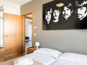 a bedroom with a poster of the beatles on the wall at Appartamento Benji1 in Nago-Torbole +19 photos