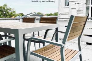 a wooden table and chairs on a balcony at Haus Lieke Deeler in Norderney