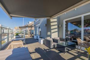 een patio met stoelen en een tafel en een balkon bij Hotel De Koningshof in Noordwijk aan Zee