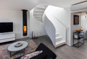 a white living room with a spiral staircase at Penthouse mit Dachterrasse, Meerblick, Klimaanlage, Gasgrill, Kamin, Luxus-Design-Apartment, 2 Minuten zum Strand in Binz
