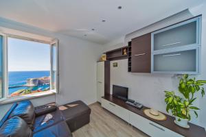 a living room with a couch and a large window at Apartment Astelas in Dubrovnik