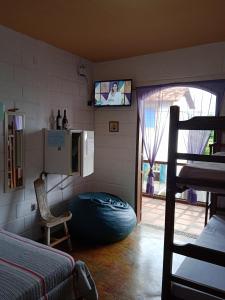 ein Schlafzimmer mit einem Bett und einem TV an der Wand in der Unterkunft Pousada Fonte Viva in Lavras Novas