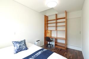 ein kleines Schlafzimmer mit einem Bett und einem Schreibtisch in der Unterkunft オーシャンヴィラ徳之島-Ocean Villa Tokunoshima- in Tokunoshima