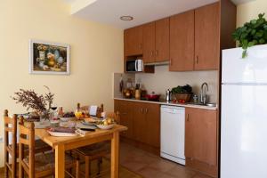 a kitchen with a table and a white refrigerator at Apartament SIAT in Queralbs