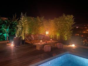 a patio with a couch and a table next to a pool at Casa Tanio 150m walking from the village and town of Tamariu in Tamariu