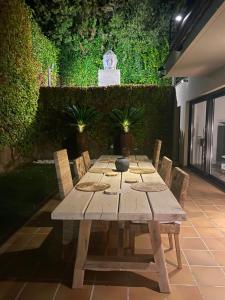 a wooden table with chairs in a garden at Casa Tanio 150m walking from the village and town of Tamariu in Tamariu