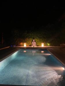 uma pessoa de pé em uma piscina à noite em Casa Tanio 150m walking from the village and town of Tamariu em Tamariu