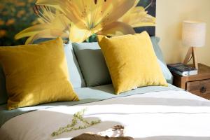 Un dormitorio con una cama con almohadas amarillas. en Apartament SIAT, en Queralbs