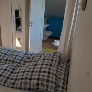 ein Bett mit einer karierten Decke in einem Zimmer in der Unterkunft Belvedere B&B in Svendborg
