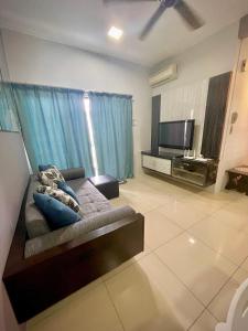 a living room with a couch and a flat screen tv at Pool View Water Theme Park at Swiss Garden Residence - 2 bedroom apartment in Kuantan