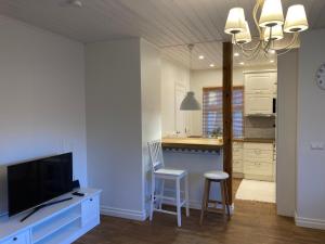 a kitchen with a tv and a table with chairs at Lossi Apartment in Kuressaare