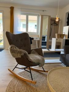 einen Stuhl mit Faux-Fell drauf, der im Wohnzimmer sitzt in der Unterkunft Moderne Ferienwohnung zum Wohlfühlen in Lindenberg im Allgäu
