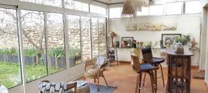 uma sala de estar com janelas e uma mesa e cadeiras em malitourne em Brissac-Quincé