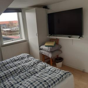 a bedroom with a bed and a flat screen tv at Svendborg Cosy in Svendborg