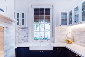a white kitchen with a sink and a window at Luxury 1850s Fremantle Home with Free Parking in Fremantle