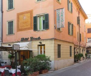 un edificio con ristorante in una strada cittadina di Hotel Torcolo "Residenze del Cuore" a Verona