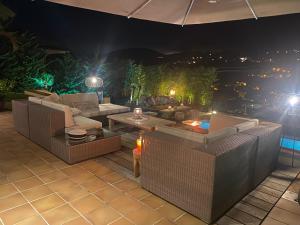 a patio with couches and a table and an umbrella at Casa Tanio 150m walking from the village and town of Tamariu in Tamariu +30 photos